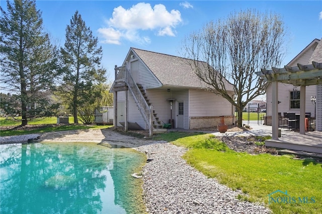back of property with roof with shingles, a pergola, stairs, a deck, and a pool