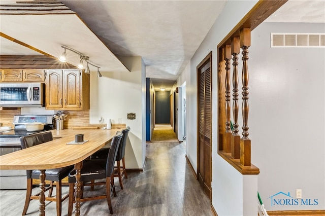 interior space with baseboards, visible vents, and dark wood-style floors