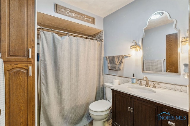 bathroom featuring curtained shower, toilet, and vanity