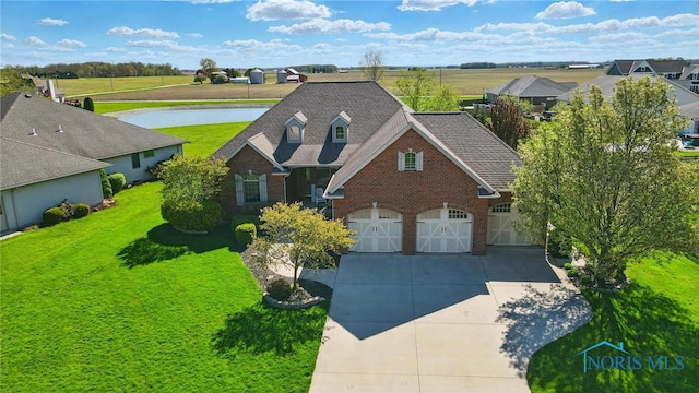 view of front of home with a garage, concrete driveway, a front yard, and brick siding