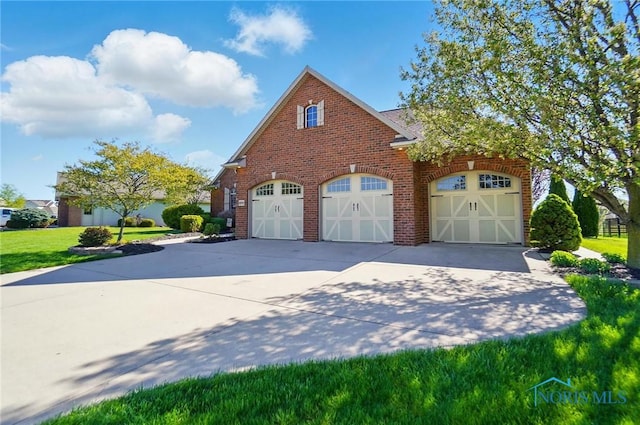 exterior space featuring concrete driveway, a front yard, and brick siding