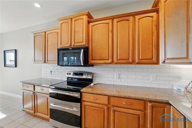 kitchen featuring backsplash, double oven range, light stone counters, baseboards, and light tile patterned flooring