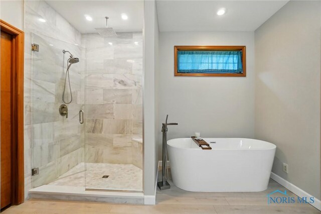 bathroom featuring a freestanding bath, baseboards, a stall shower, and recessed lighting
