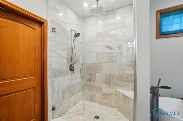 full bath with a soaking tub and a stall shower