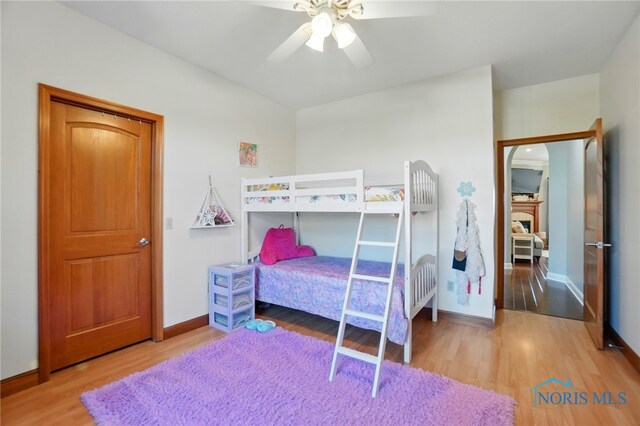 bedroom featuring a ceiling fan, baseboards, and wood finished floors