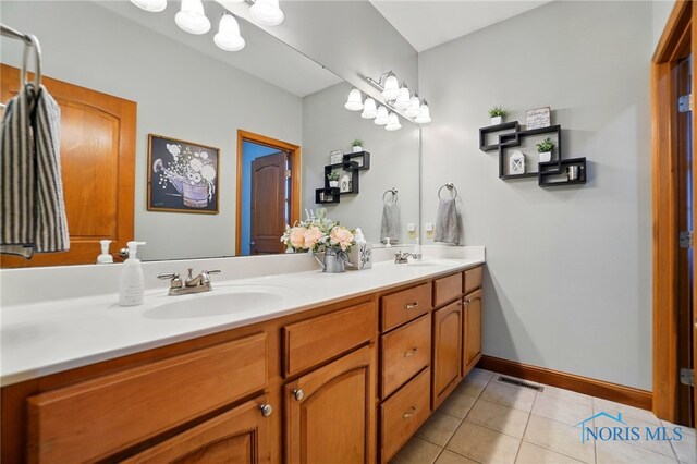 full bath featuring double vanity, tile patterned floors, visible vents, and a sink