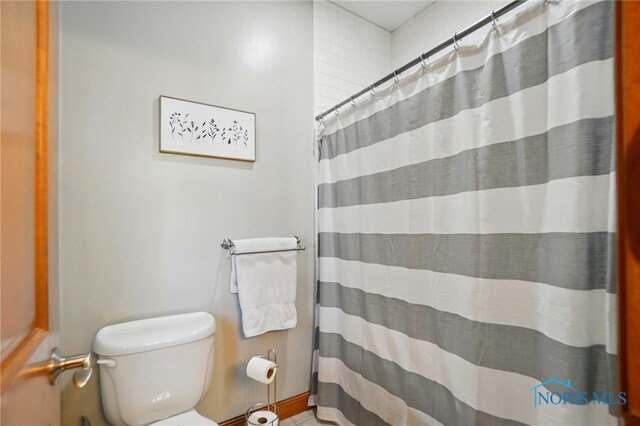 bathroom with toilet, a shower with curtain, and tile patterned flooring
