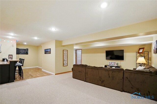living room featuring recessed lighting, baseboards, and light carpet