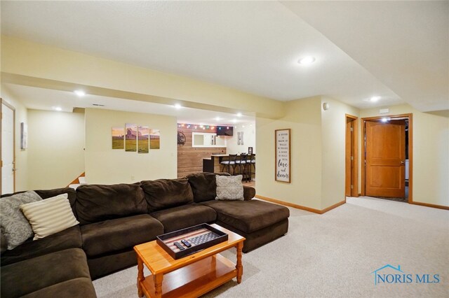 living area featuring baseboards, light carpet, bar, and recessed lighting