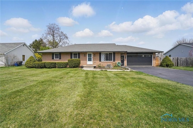 single story home with a front yard, brick siding, fence, aphalt driveway, and an attached garage