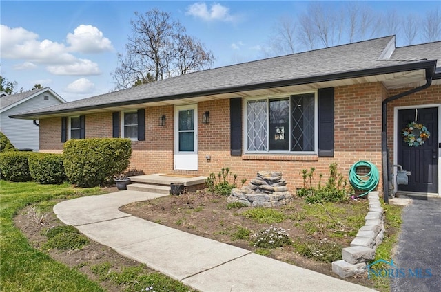 ranch-style house with brick siding and a shingled roof