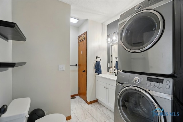 washroom with stacked washing maching and dryer, baseboards, a sink, and marble finish floor