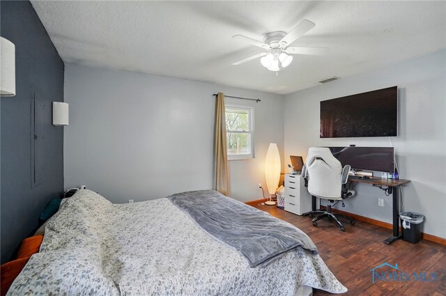bedroom with baseboards, a ceiling fan, wood finished floors, and visible vents