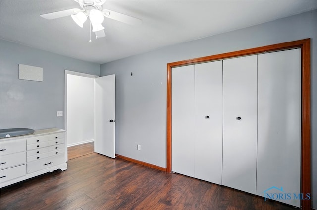 unfurnished bedroom with baseboards, ceiling fan, a closet, and dark wood-style flooring