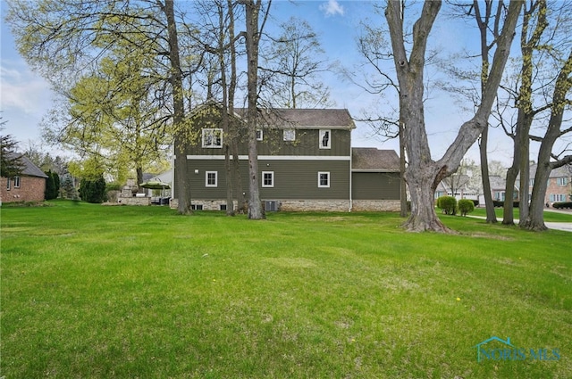 back of property with cooling unit and a yard