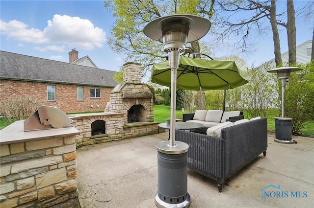 view of patio featuring an outdoor kitchen and an outdoor living space with a fireplace