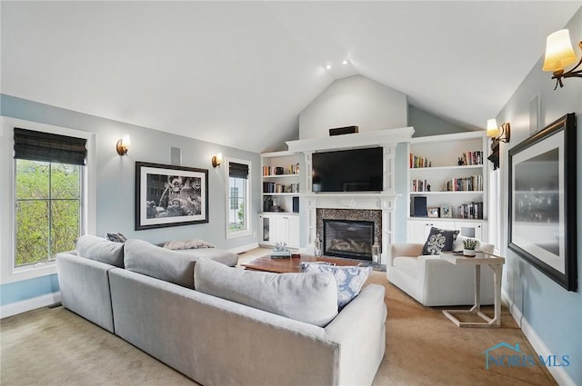 living area featuring baseboards, a high end fireplace, carpet flooring, and vaulted ceiling