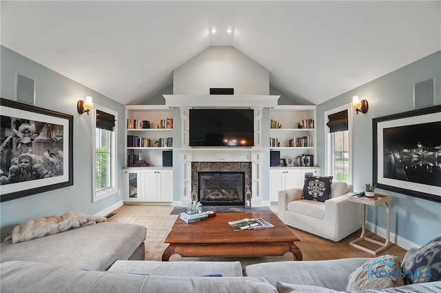 living area featuring lofted ceiling, light colored carpet, a glass covered fireplace, and baseboards