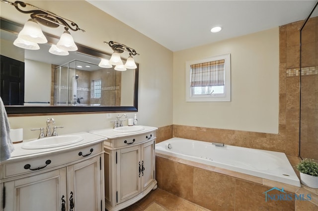 full bathroom featuring a garden tub, two vanities, a sink, and tile patterned flooring
