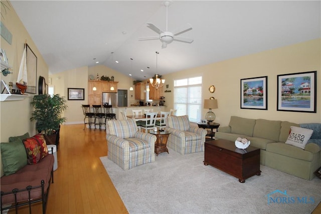 living area featuring light wood-style flooring, high vaulted ceiling, and ceiling fan with notable chandelier