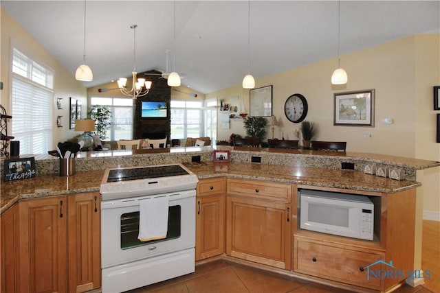 kitchen featuring vaulted ceiling, plenty of natural light, open floor plan, white appliances, and a notable chandelier