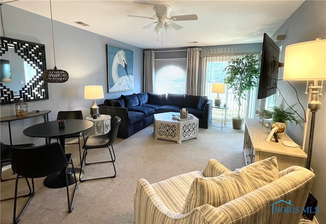 living room with a ceiling fan, carpet flooring, and visible vents