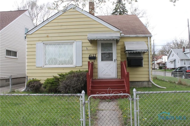 bungalow with a gate, a chimney, a front yard, and a fenced front yard