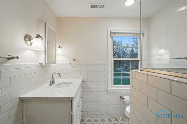 160 Winfield Dr, Bowling Green, OH 43402 - bathroom with tile patterned floors, visible vents, toilet, tile walls, and wainscoting