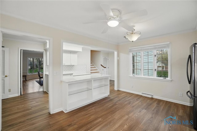 160 Winfield Dr, Bowling Green, OH 43402 - unfurnished living room featuring dark wood finished floors, a healthy amount of sunlight, crown molding, and visible vents