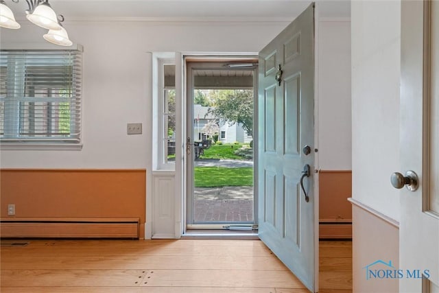 325 Park St, Bryan, OH 43506 - entryway featuring wood finished floors, crown molding, and a baseboard radiator