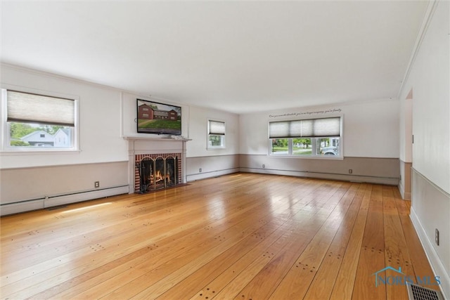 325 Park St, Bryan, OH 43506 - unfurnished living room featuring a baseboard radiator, hardwood / wood-style floors, and a brick fireplace