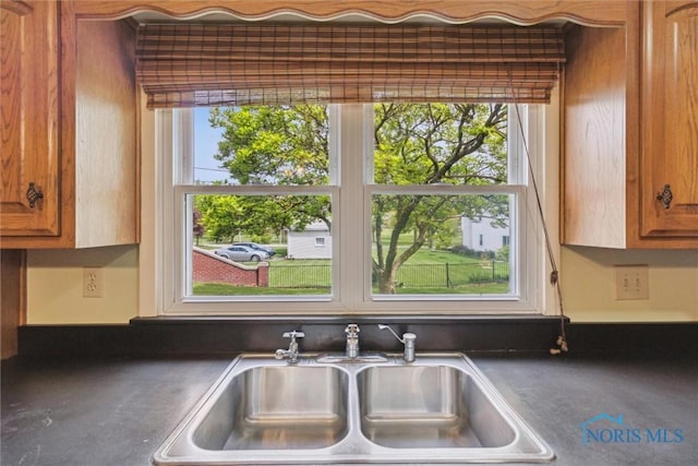 325 Park St, Bryan, OH 43506 - kitchen view of a sink, brown cabinetry, and dark countertops