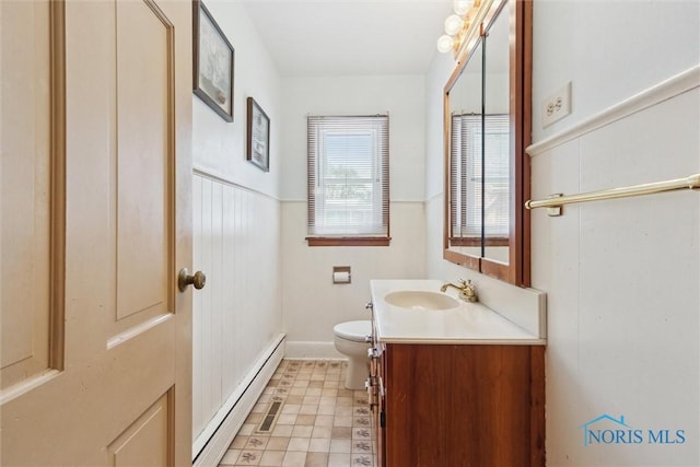 325 Park St, Bryan, OH 43506 - half bathroom with a baseboard heating unit, vanity, toilet, and baseboards
