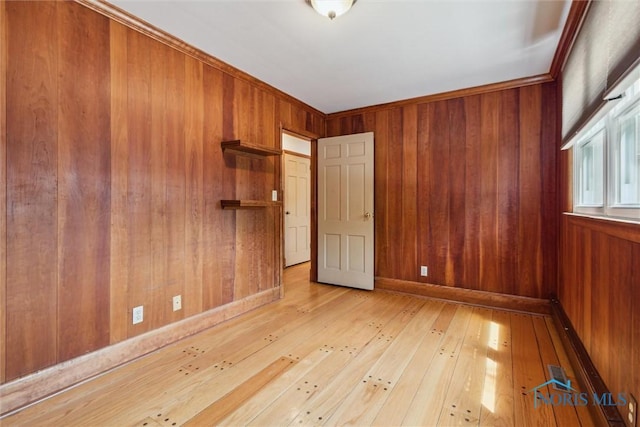325 Park St, Bryan, OH 43506 - spare room featuring wooden walls, light wood-style floors, and baseboards