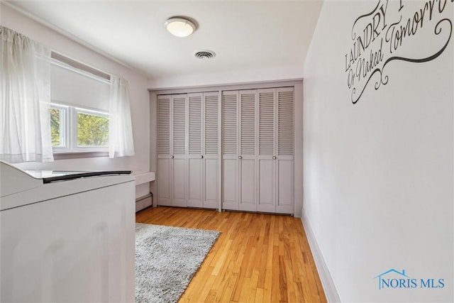 325 Park St, Bryan, OH 43506 - unfurnished bedroom with a baseboard heating unit, wood finished floors, a closet, and baseboards