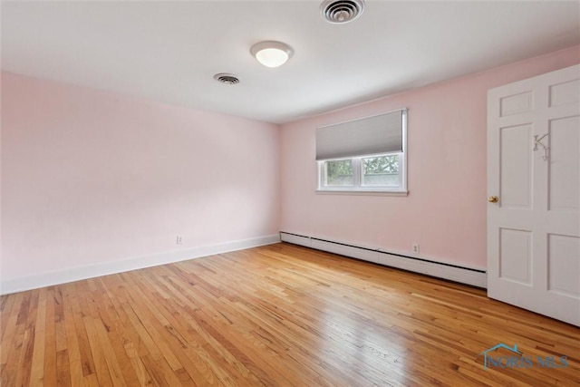325 Park St, Bryan, OH 43506 - empty room with a baseboard heating unit, light wood finished floors, and baseboards