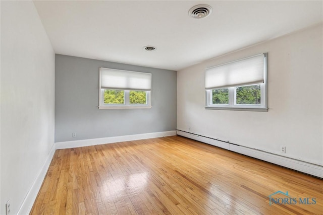 325 Park St, Bryan, OH 43506 - spare room with a baseboard heating unit, hardwood / wood-style flooring, and baseboards