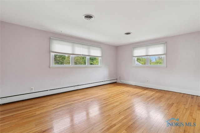 325 Park St, Bryan, OH 43506 - unfurnished room with baseboard heating, plenty of natural light, wood-type flooring, and baseboards