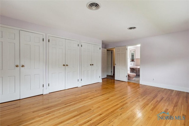 325 Park St, Bryan, OH 43506 - unfurnished bedroom with multiple closets, light wood-type flooring, baseboards, and ensuite bathroom