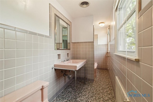 325 Park St, Bryan, OH 43506 - bathroom with toilet, tile walls, wainscoting, and a sink