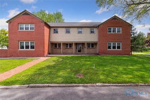 325 Park St, Bryan, OH 43506 - rear view of house featuring brick siding and a lawn