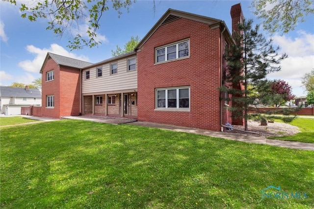 325 Park St, Bryan, OH 43506 - rear view of house with brick siding, a chimney, and a yard