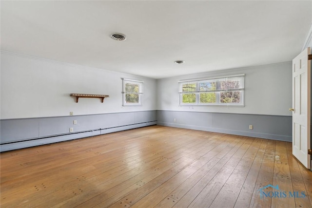 325 Park St, Bryan, OH 43506 - spare room featuring a baseboard radiator, wood-type flooring, and baseboards