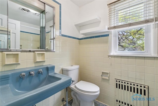 325 Park St, Bryan, OH 43506 - bathroom with radiator heating unit, tile walls, toilet, and a sink