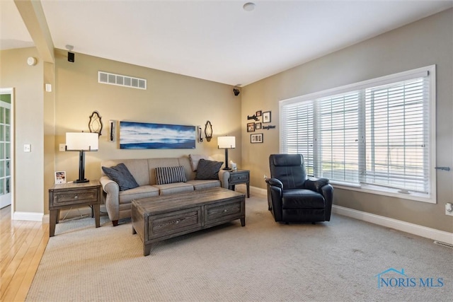 living area with baseboards, wood finished floors, and visible vents