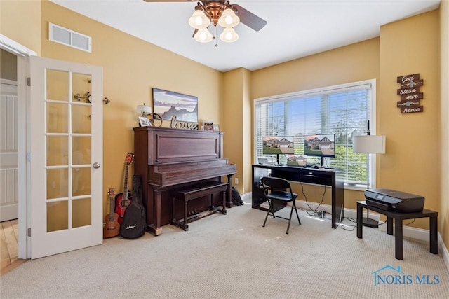 carpeted home office featuring baseboards, a ceiling fan, and visible vents