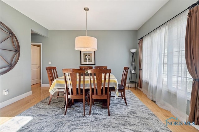 dining room with baseboards and light wood finished floors