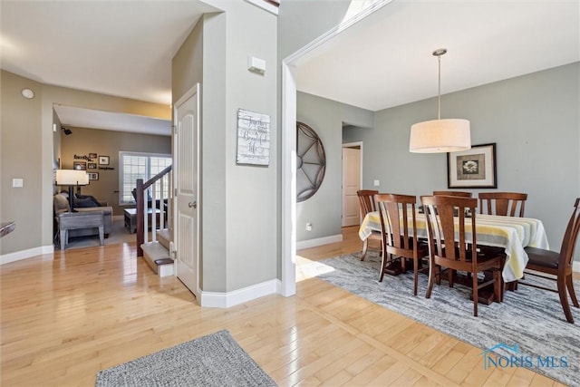 dining area with light wood-style floors and baseboards