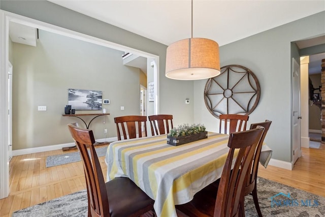 dining area featuring baseboards and light wood finished floors