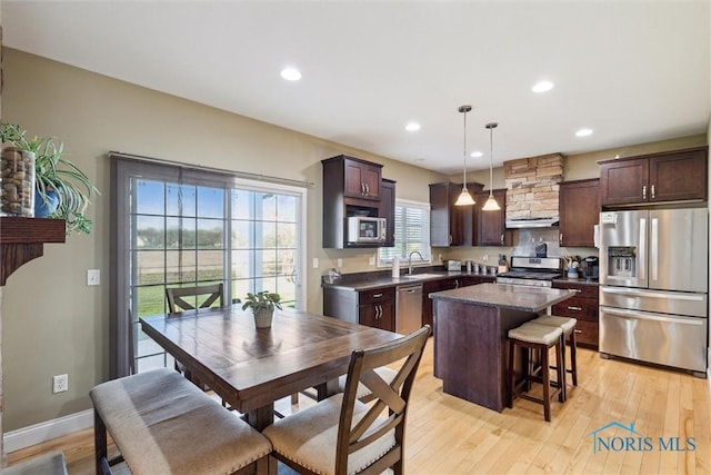 4218 Herdmans Cir, Maumee, OH 43537 - kitchen featuring stainless steel appliances, a sink, a center island, dark countertops, and light wood finished floors